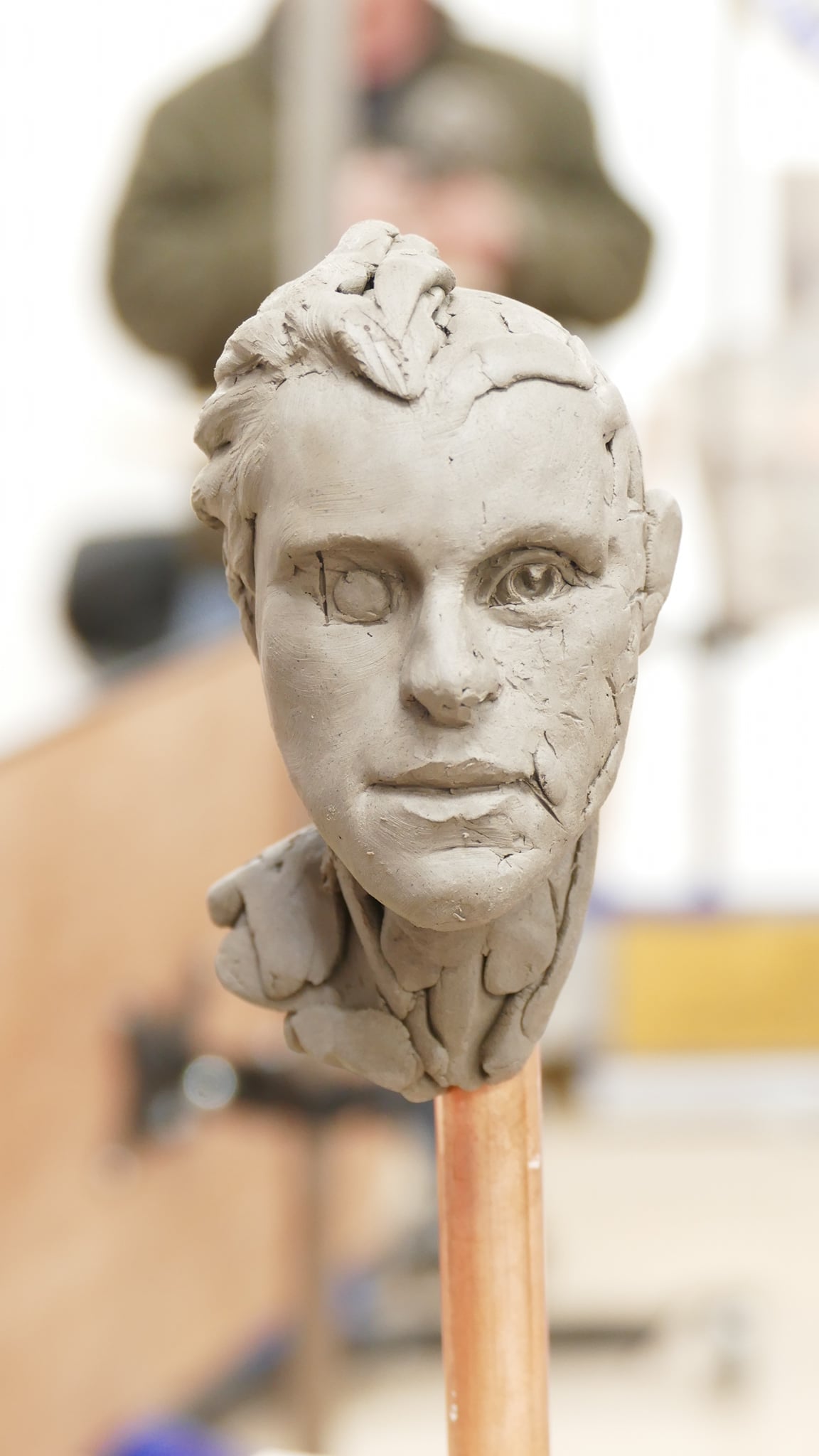 clay sculpture of a head on a stick