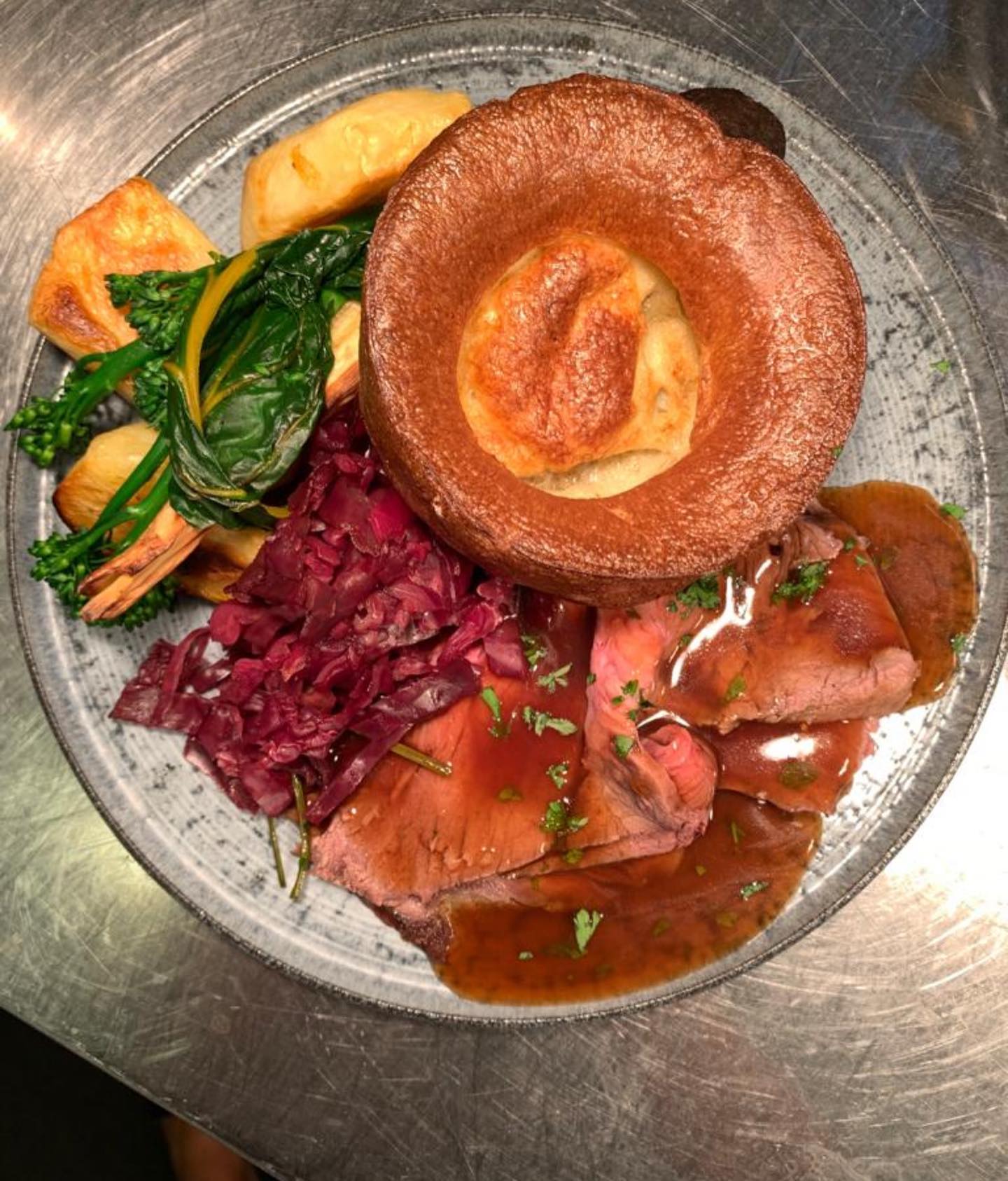 a plate of roast dinner with a large yorkshire pudding